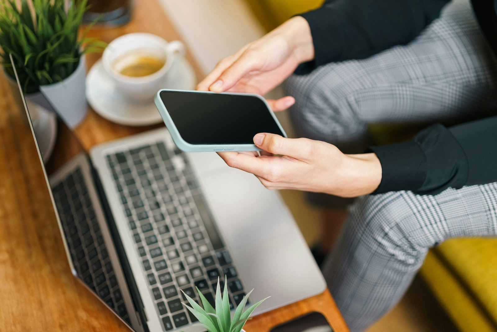 Persona utilizando un teléfono móvil para contactar con Malucalú y solicitar información sobre actividades extraescolares.