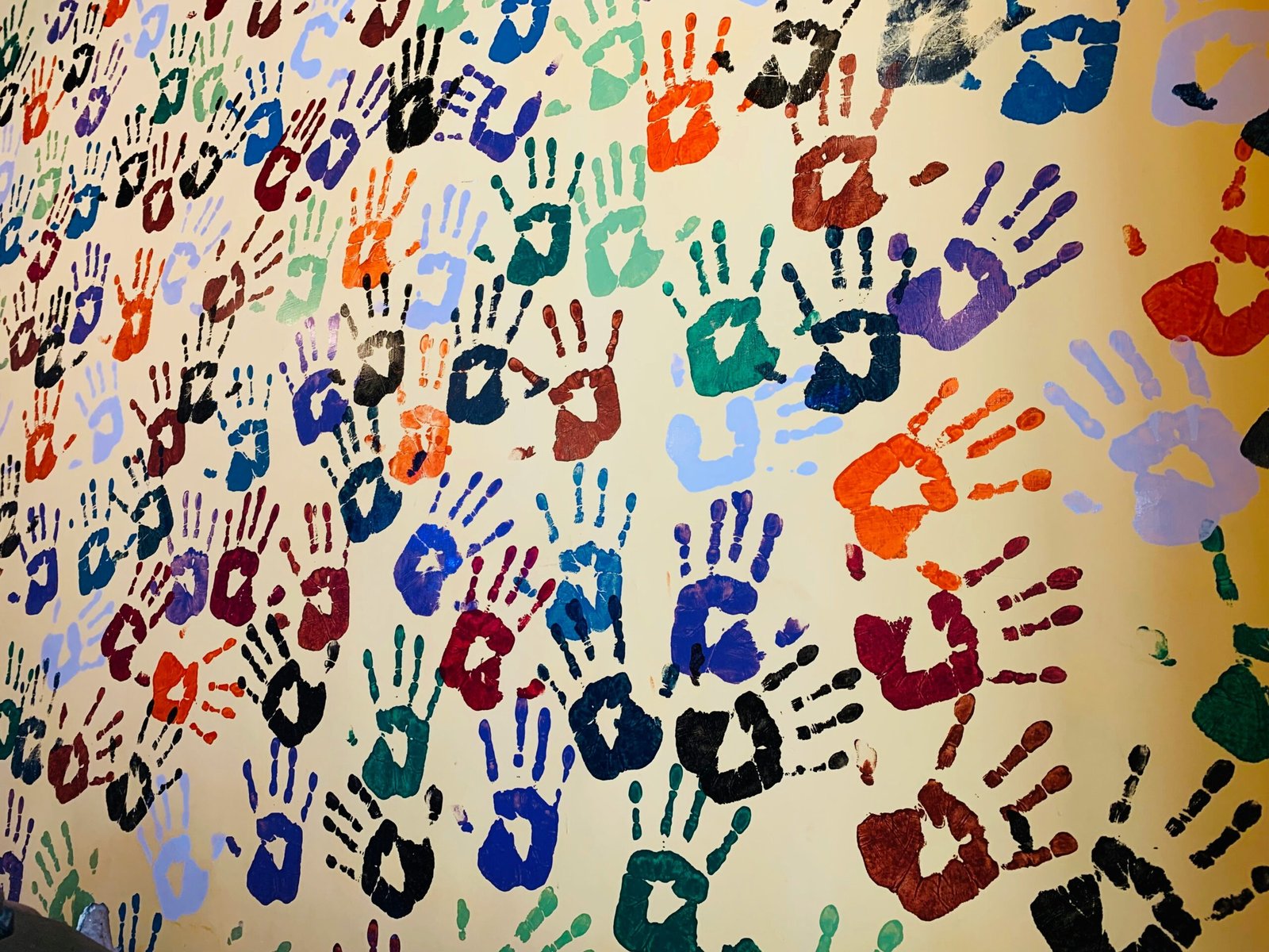 Mural de huellas de colores realizado por niños durante actividades creativas y de ocio en Malucalú